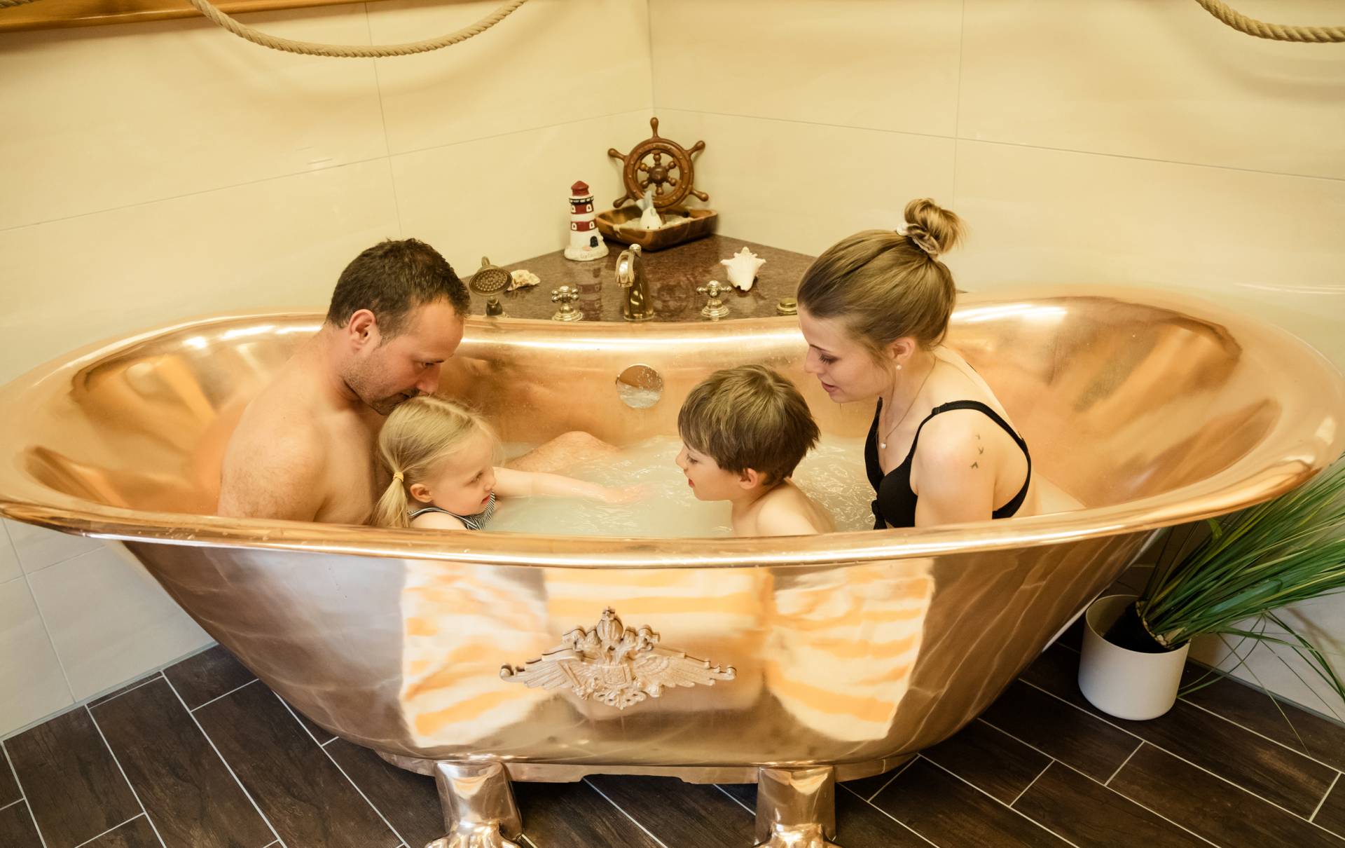 Familie in goldener Badewanne beim Wellness im Hotel Seeklause Usedom