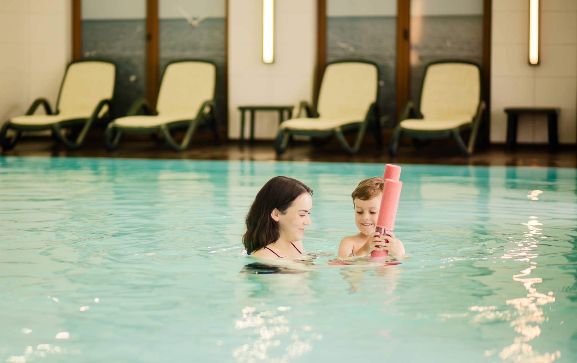 Schwimmlehrerin und Kind beim Schwimmkurs im Pool