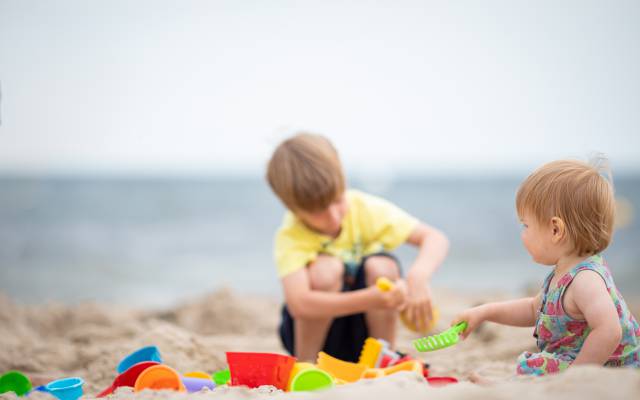 Kinder mit Sandspielzeug am Strand der Ostsee auf Usedom