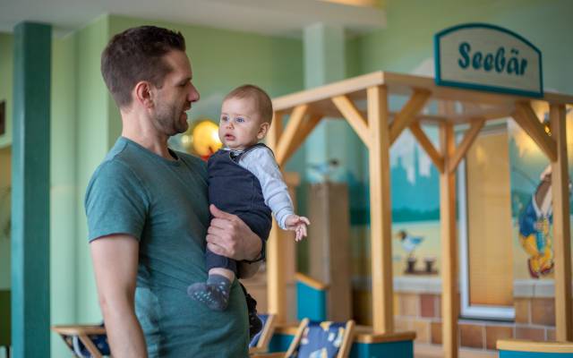 Vater mit Baby beim Spielschiff "Seebär"